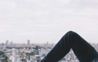 Man looking sad as he looks outside the window into the city
