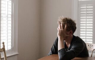 Photo of man leaning on wooden table