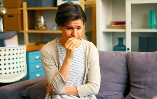Male therapist listening while a client talks from a sofa during therapy.